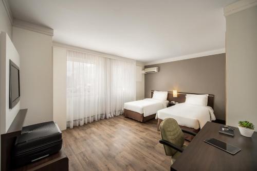 圣保罗Intercity São Paulo Nações Unidas的酒店客房配有两张床和一张书桌