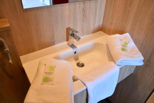 欧里亚克The Originals Access Aéroport, Hôtel Aurillac的浴室设有水槽和2条毛巾