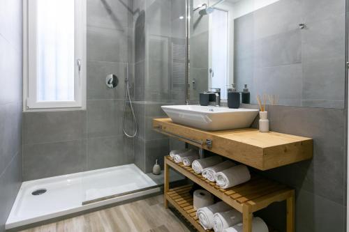 米兰Milanofierapartments的浴室配有水槽、淋浴和浴缸。