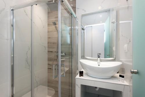 卡西奥皮Melina Bay Boutique Hotel的一间带水槽和玻璃淋浴的浴室