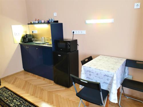 布达佩斯Madana apartman的厨房配有桌子和小桌子及椅子