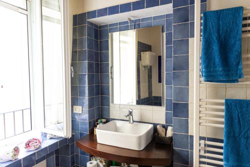 MugnanoCasa vacanze al Castello.的蓝色瓷砖浴室设有水槽和镜子