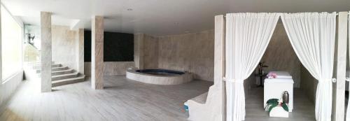萨卡特卡斯唐米格尔酒店的一间带浴缸的浴室位于客房中间