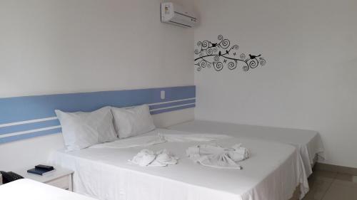 塞古罗港Hotel Ponta de Areia的一张白色的床,上面有两条白色毛巾