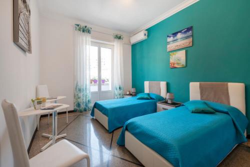 罗马Dream House spazioso appartamento tra Policlinico e Piazza Bologna的一间蓝色卧室,配有两张床和一张桌子
