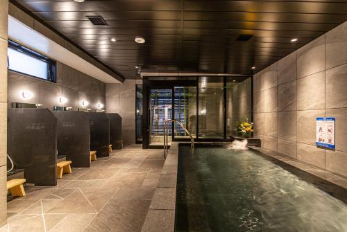 东京HOTEL AMANEK Kamata-Eki Mae的大楼中央带游泳池的浴室