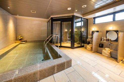 东京HOTEL AMANEK Kamata-Eki Mae的大型浴室设有浴缸和淋浴。
