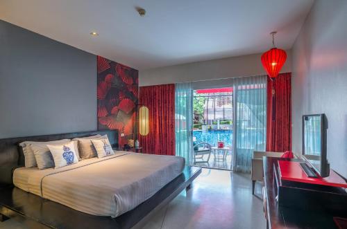 奥南海滩Red Ginger Chic Resort by Tolani - SHA Extra Plus的一间卧室配有一张床、一张书桌和一个窗户。