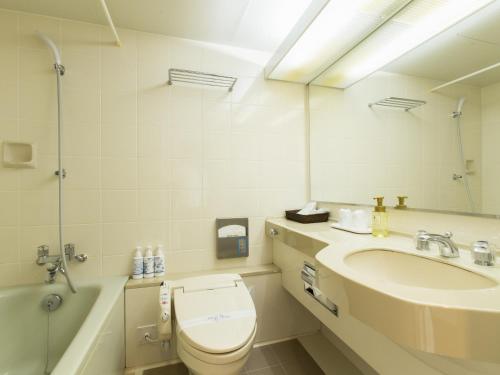 丰冈市蓝岭酒店的浴室配有卫生间、盥洗盆和浴缸。