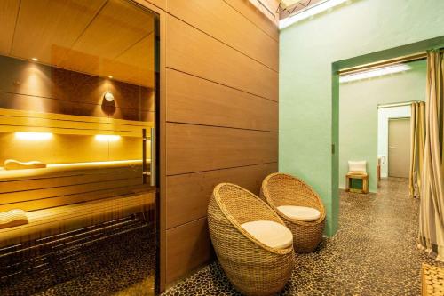 贝莱斯塔Domaine Riberach - Restaurant étoilé - Spa - Piscine naturelle - Vignoble bio的浴室设有2把藤椅和镜子
