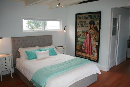 奥克兰The Boat House的卧室配有一张壁挂式海报的床