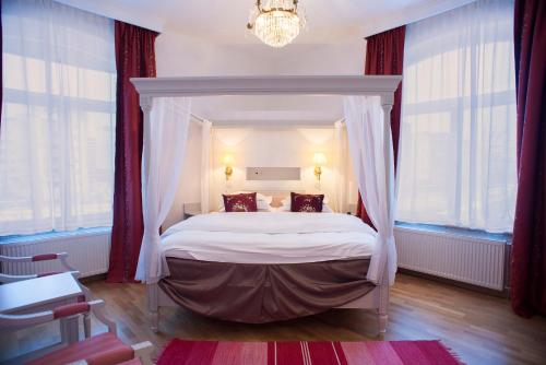 斯德哥尔摩布罗姆马韦克酒店的一间卧室配有一张带红色窗帘的天蓬床