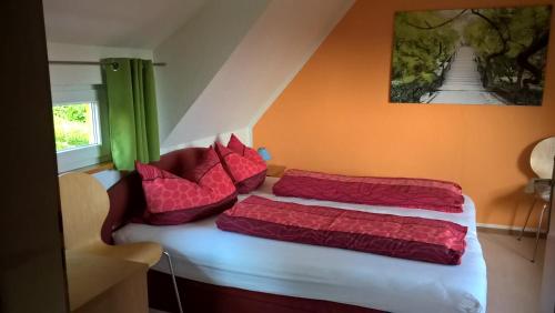 库罗阿尔滕堡Ferienhaus Fernblick Altenberg的一间卧室配有两张带红色枕头的床