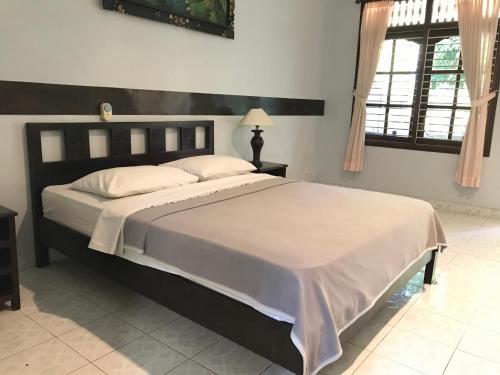勒吉安芒加巴厘岛酒店的一间卧室,卧室内配有一张大床