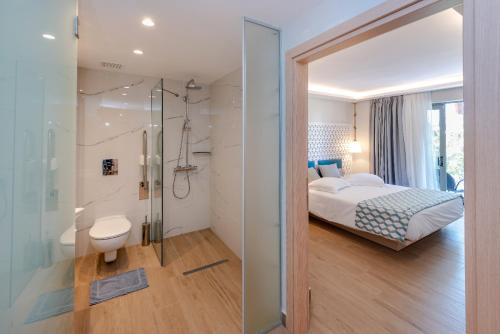 科斯镇Triton Boutique Hotel的一间卧室配有一张床,浴室设有淋浴。