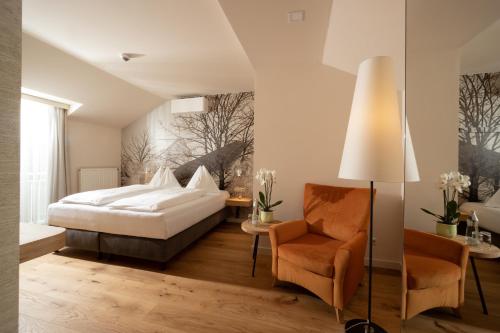 魏茨Hotel-Restaurant Allmer的一间卧室配有一张床和一把椅子
