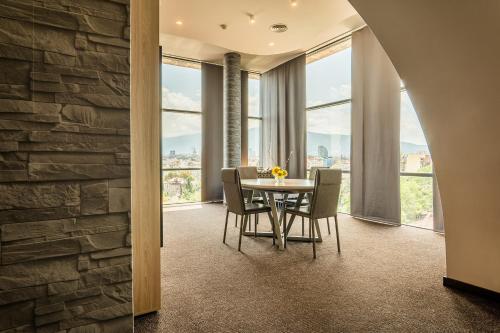 索非亚布达佩斯酒店的一间带桌椅和窗户的用餐室
