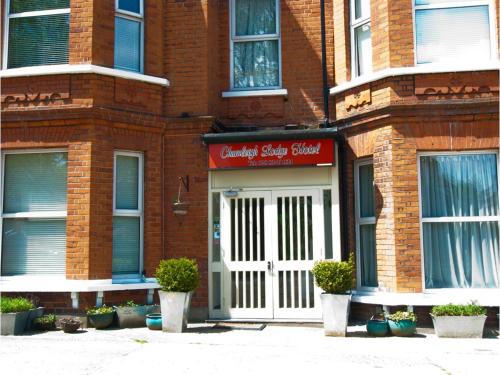 亨顿Chumleigh Lodge Hotel Ltd.的红砖建筑,有白色门和植物