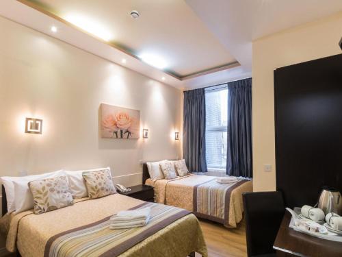 伦敦诺丁山大门酒店的酒店客房设有两张床和窗户。