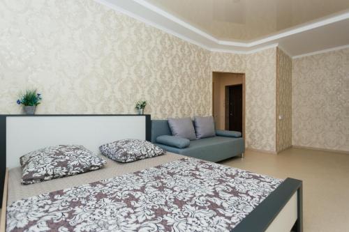 苏梅Luxury apart-hotel on Kharkovskaya New Building 6 floor的一间卧室配有一张床和一张沙发