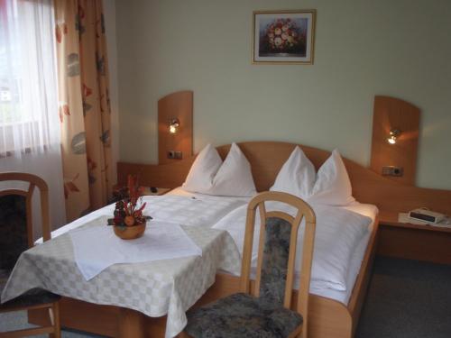卡普伦Haus Koller的酒店客房带一张床、一张桌子和椅子