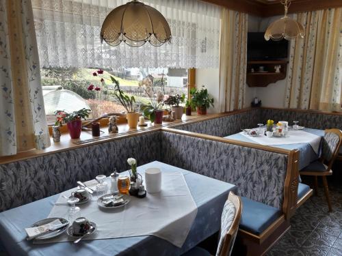 卡普伦Haus Koller的一间设有两张桌子和窗户的用餐室