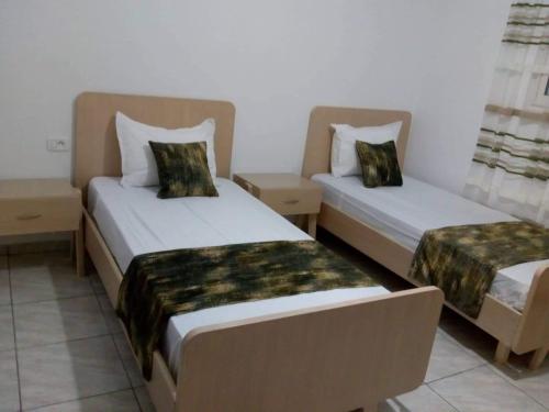 阿格希尔Villa de luxe avec piscine privée sans vis à vis à Djerba的配有衬衫的酒店客房内的两张床