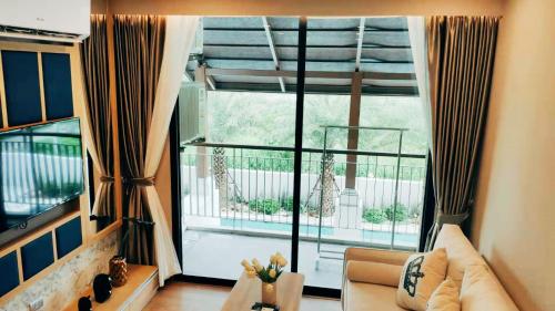 清迈Pleasant Chiangmai的带沙发和大窗户的客厅