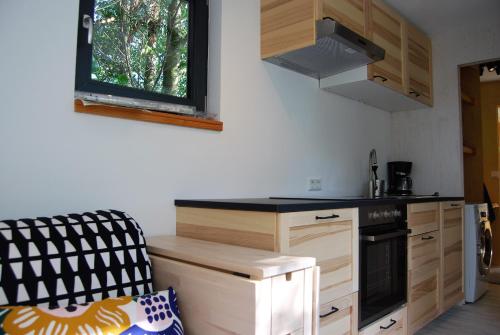 茨韦特尔Tiny House Ruheoase的厨房配有木制橱柜和炉灶烤箱。