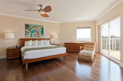 圣徒皮特海滩Crystal Palms Beach Resort的一间卧室配有一张大床和一把椅子