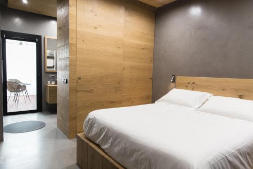 坎塔卢普斯El Recer de Masia Serra的一间卧室设有一张床和木墙