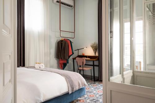 贝鲁特Hotel Lost的一间卧室配有一张床、一张书桌和一个窗户。