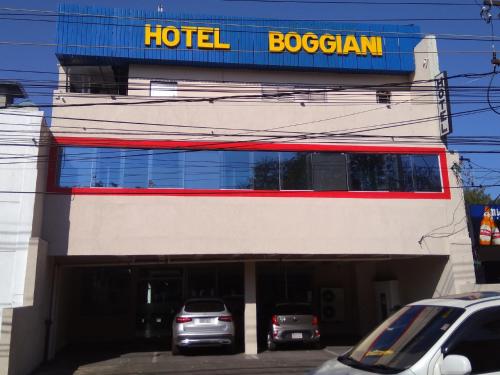 亚松森Hotel Boggiani的一辆汽车停在大楼前的酒店