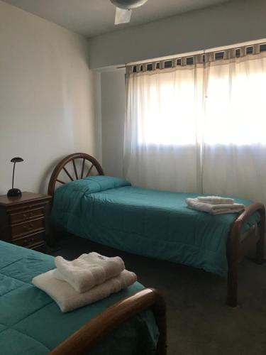布兰卡港Departamento amoblado en pleno centro, con cochera的一间卧室设有两张床和窗户。