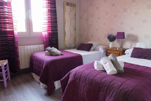 Cogeces de IscarCasa Abuela Nila的一间设有两张紫色床单的床的客房
