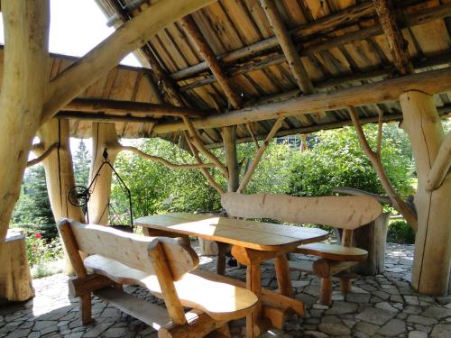 布科维纳-塔钱斯卡密斯家庭式旅馆的木屋顶下的木桌和椅子
