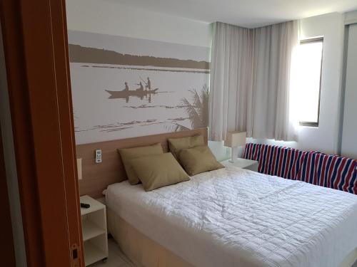 拉巴拉德纳圣米格尔Iloa Residence Resort - Barra de São Miguel的卧室配有一张床,墙上挂有绘画作品