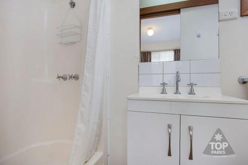 彼得伯勒大洋路观光园酒店的白色的浴室设有浴缸和水槽。