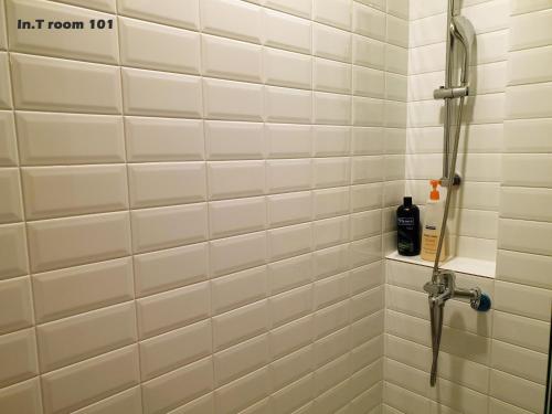 台南In.T 的浴室设有白色瓷砖墙壁和淋浴。