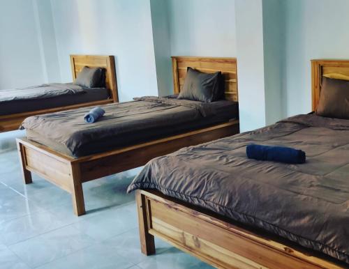 普卢坎Medewi Beach Inn的卧室内的两张床和蓝色枕头