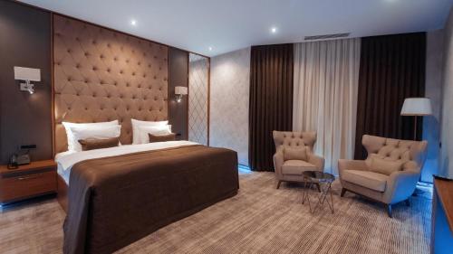 巴库Midtown Hotel Baku的酒店客房,配有一张床和两把椅子