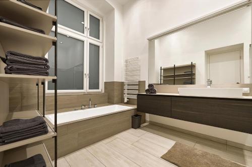 维也纳Central Luxury Apartment的带浴缸、水槽和镜子的浴室