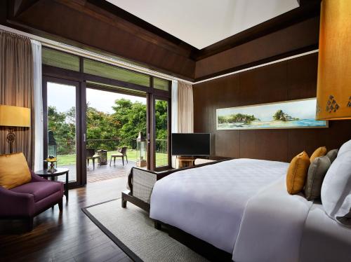 库塔巴厘岛安瓦雅海滩度假酒店的一间带一张白色大床的卧室和一个阳台