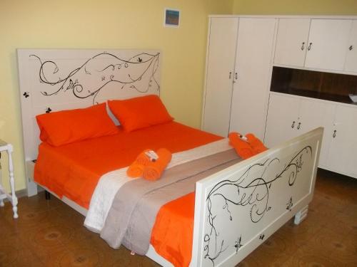 MontauroWelcome to the "Rossinelli Lodge"的一间卧室配有带橙色枕头的床