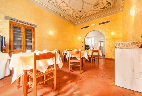 佛罗伦萨科斯坦缇尼酒店的一间在房间内配有桌椅的餐厅