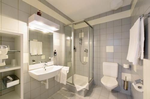 Orbe马赛克酒店的一间带水槽、淋浴和卫生间的浴室