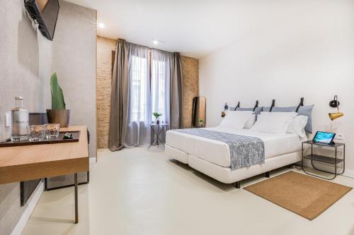 巴塞罗那Casa Lirio的白色卧室配有床和书桌