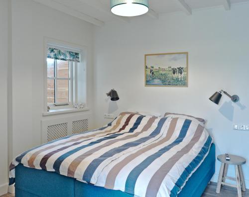 HarenB&B d'n Uilenhof Haren的一间卧室配有带条纹毯子的床
