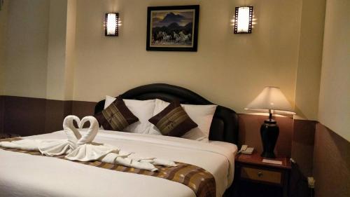 曼谷拜客套房旅馆的酒店客房的床铺上带一条带