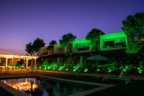 菲内斯特拉特Nature Suites Puig Campana by AR Hotels & Resorts的夜间在大楼前的游泳池